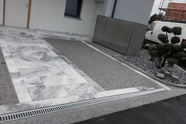 Hauseingang mit Steinplatten und Entwässerungsrinne